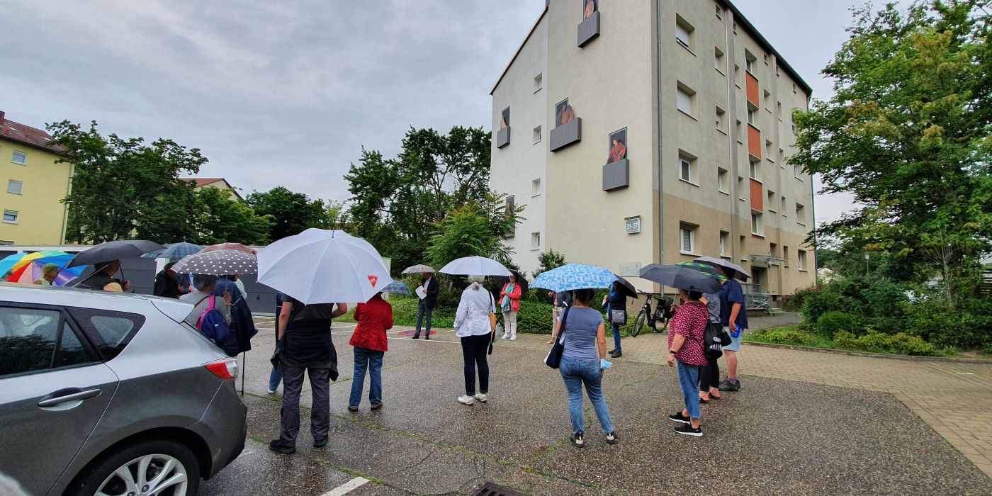 Spaziergang im „Malerviertel Haßloch-Nord“ und 20 Teilnehmern bei Regen vor dem Kunstwerk Balkonien