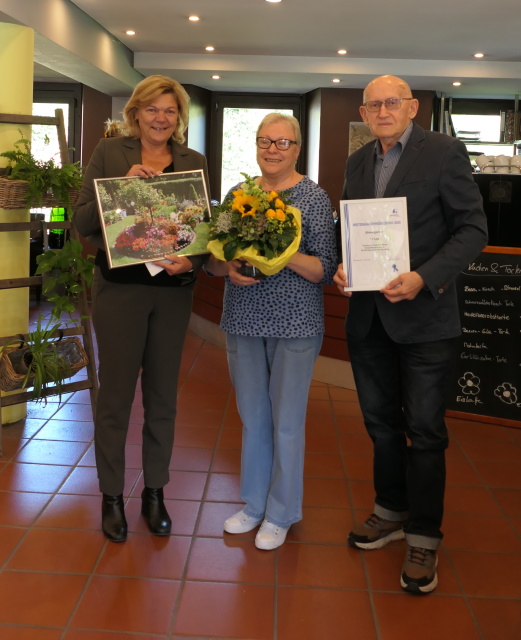 Anke Luciano ehrt Tamara und Vladimir Meser für ihr Engagement in ihrem Mietergarten