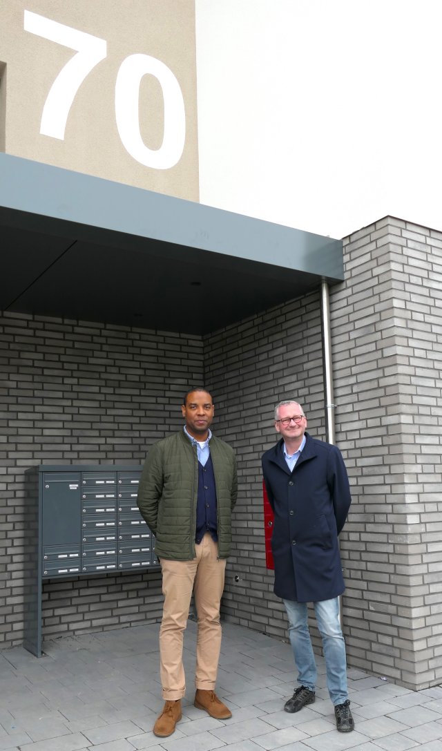 Abteilungsleiter Lian Moiba und Geschäftsführer Torsten Regensein stehen vor dem neu gestalteten Hauseingang Hasengrund 70