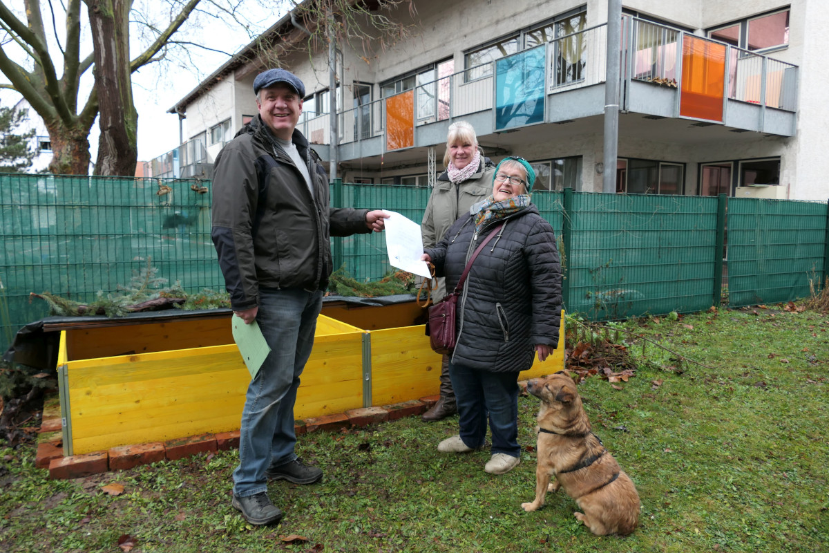 Igelsuchhund Freddie, Monika Arnold, Bianca Menssen erhalten von Hartmut Hebling vom Bereich Außenanlagen die Förderung für die Igel-Winterstation