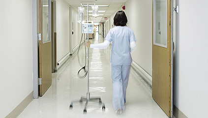 Eine Krankenschwester läuft im Gang eines Krankenhauses