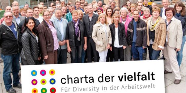 Bild zeigt gewobau Mitarbeiter mit dem Banner der Charta der Vielfalt