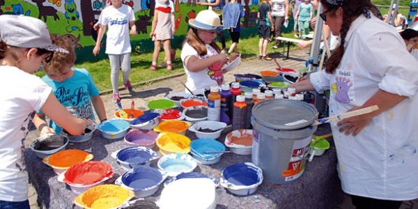 Bild zeigt eine Malaktion an einer gewobau Garagenwand mit Kindern