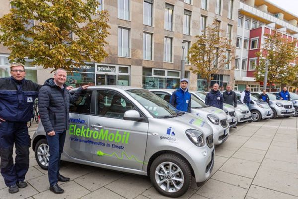 Torsten Regenstein und Mitarbeiter de gewobau stehen zeigen der E-Fuhrpark