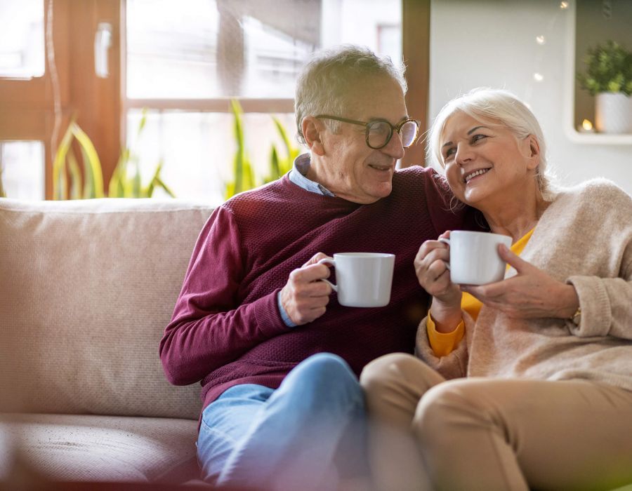 Bild eines zufriedenen Seniorenpaares kaffeetrinkend auf der Coach