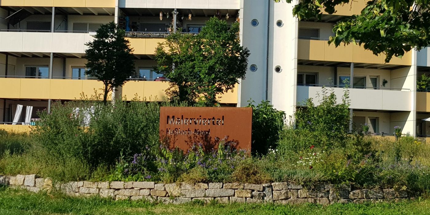 Das Eingangstor zum Malerviertel Haßloch-Nord steht auf der Grünfläche der Wohnanlage Lenbachstraße 17 - 27