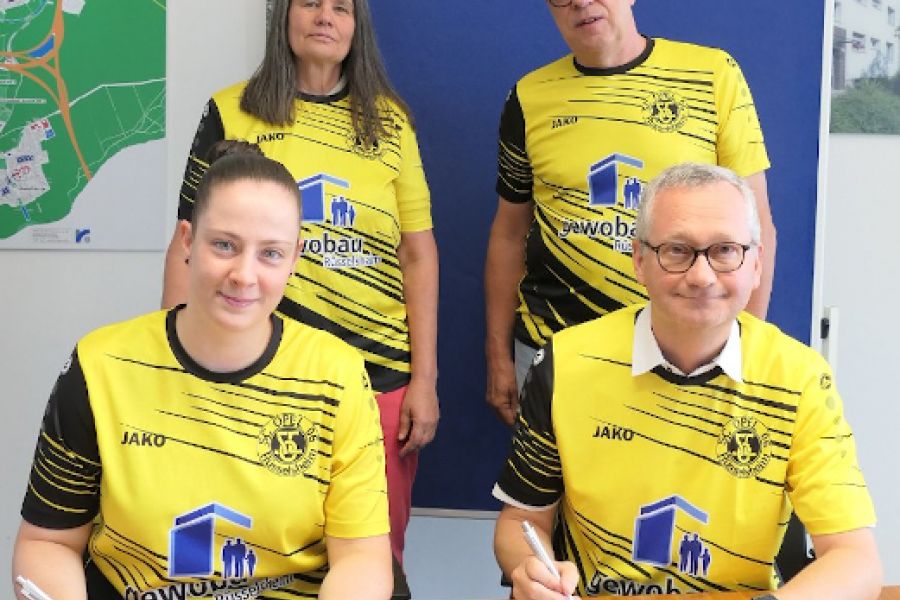 Torsten Regenstein und Jürgen Gelis mit Spielerinnen unterzeichen den Sponsoring-Vertrag der gewobau mit der Frauenfußballabteilung des SC Opel