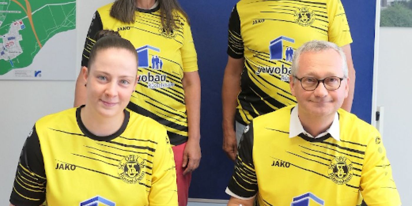 Torsten Regenstein und Jürgen Gelis mit Spielerinnen unterzeichen den Sponsoring-Vertrag der gewobau mit der Frauenfußballabteilung des SC Opel
