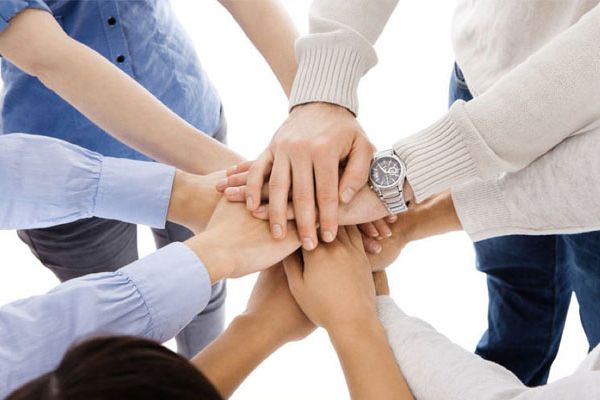 Viele Hände liegen aufeinander und symbolisieren ein faires Miteinander