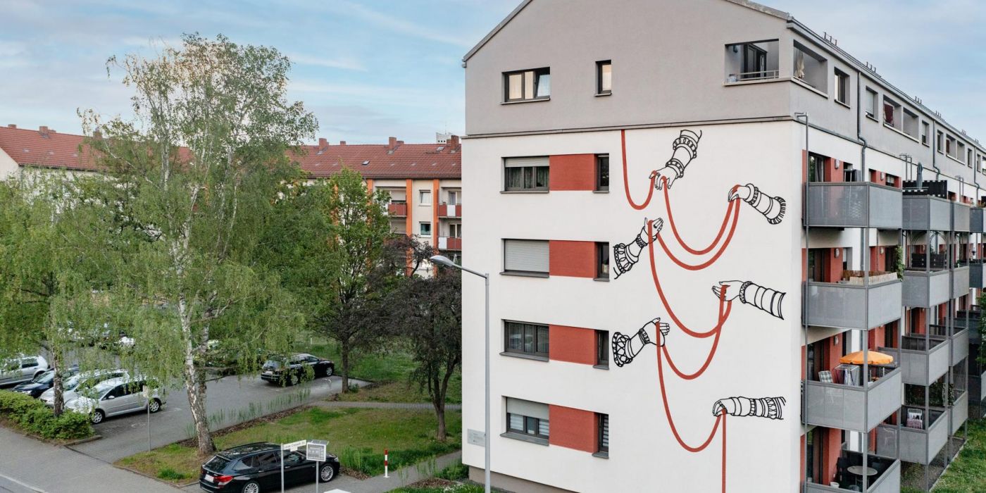 Das Kunstwerk „Weiterreichen“ an der Westfassade der gewobau Wohnanlage Lucas-Cranach-Straße 43 – 47