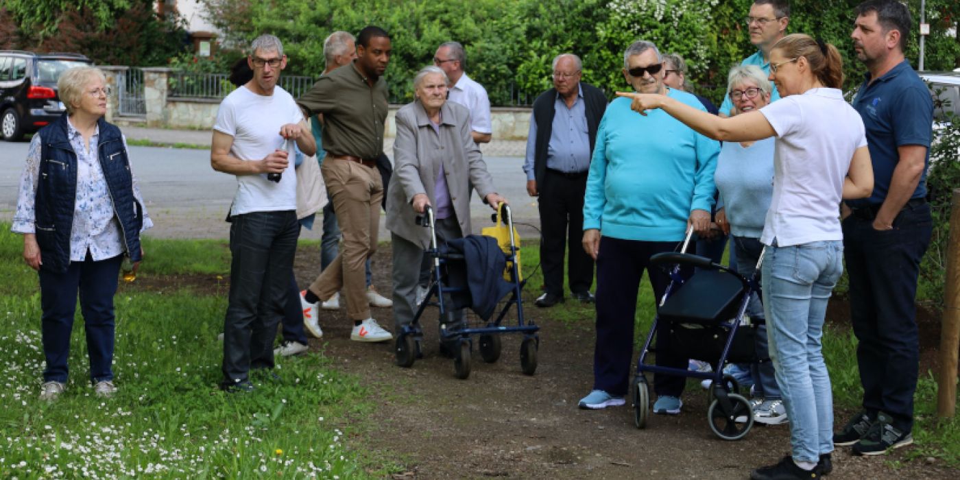 Die gewobau Mitarbeiter erlaäutern den Mietern und Mieterinnen die neue biodiverse Außenanlage