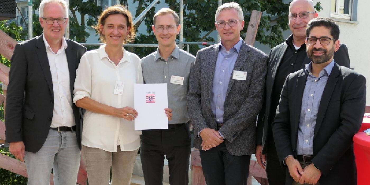 Minister Kaweh Mansoori, Hessisches Ministerium für Wirtschaft, Energie, Verkehr, Wohnen und ländlichen Raum, verlieh der gewobau Rüsselsheim, vertreten durch Prokurist Thomas Steininger und Projektleiter Joshua Hensel und den Architekten von FFM Architekten, vertreten durch Architekten Cilia und Hendrik Tovar, den 4. Hessischen Preis für Innovation und Gemeinsinn im Wohnungsbau.